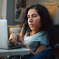 Une femme ayant un handicap physique utilise un ordinateur portatif