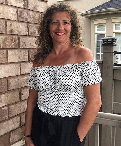 Angie - smiling woman in black polka-dot white shirt