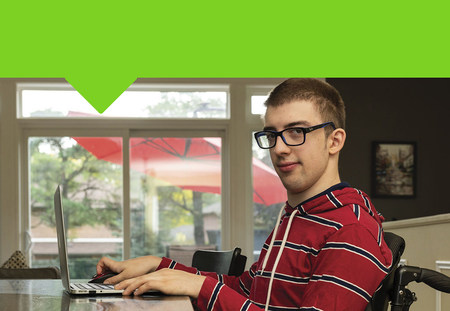 Young man in a wheelchair working on a laptop