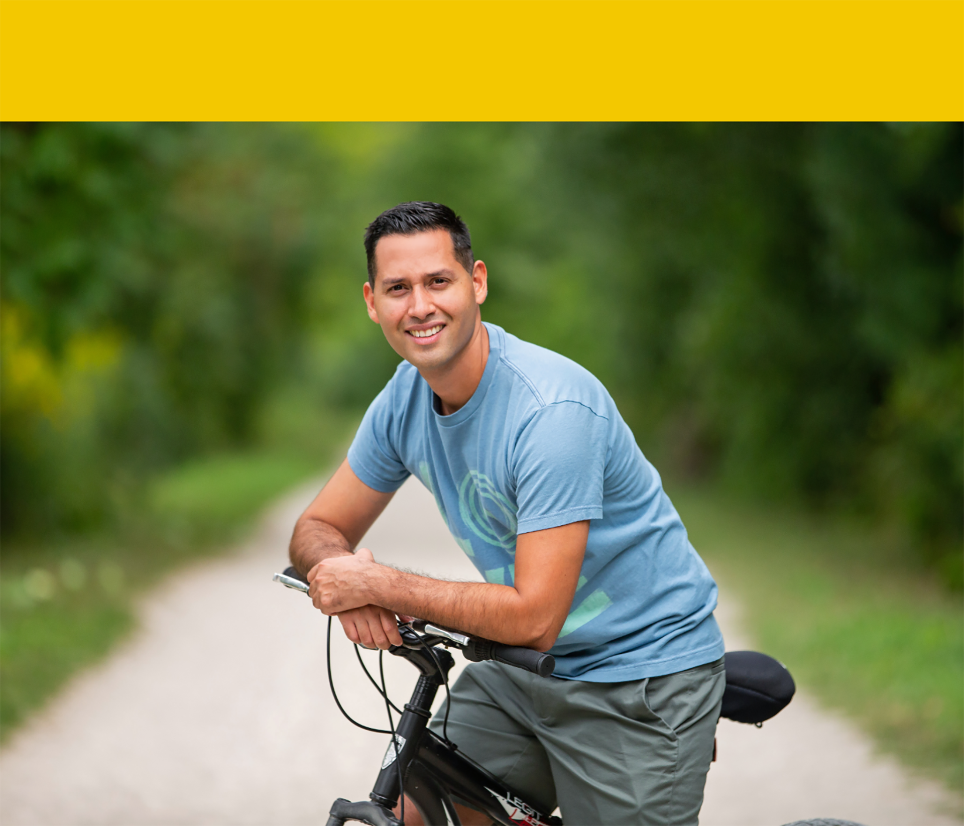 Smiling stroke survivor Jonathan Arevaln sitting on a bike