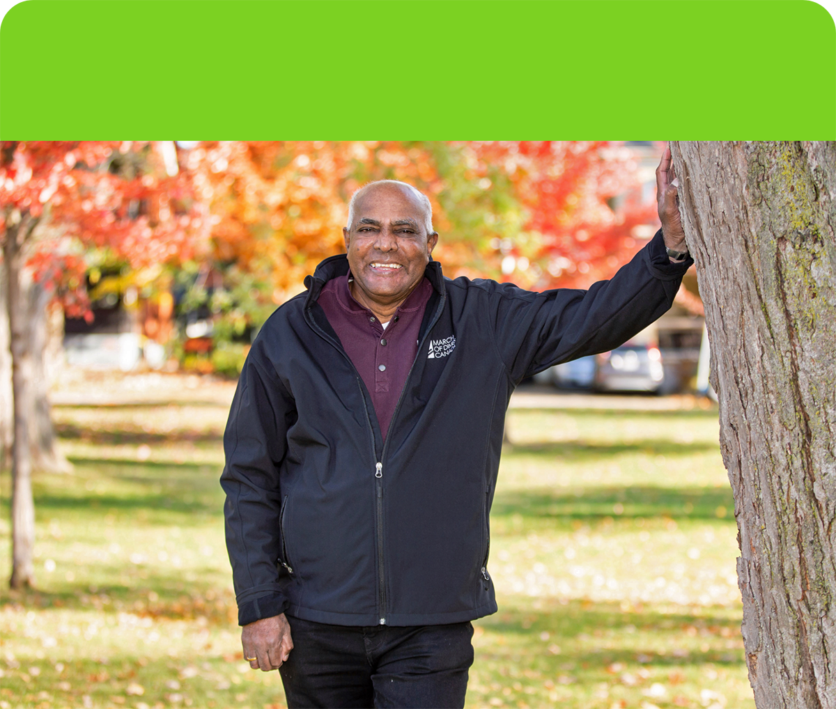 Nathan Packiyanathan leaning against a large tree with this left arm