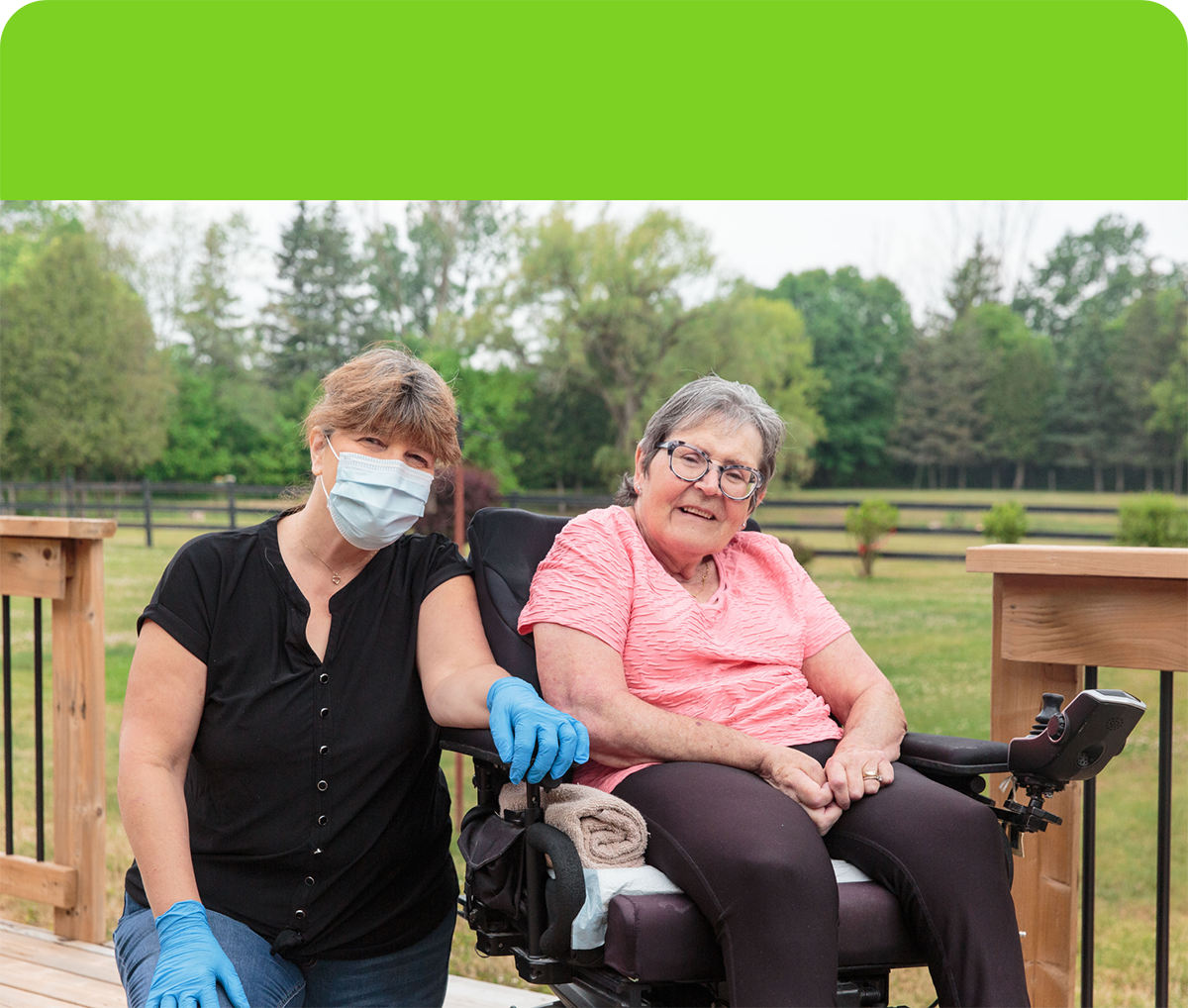 Attendant Care staff beside Rose Heulens sitting in her wheelchair on her back porch