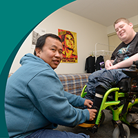 male care worker helping a man in a wheelchair