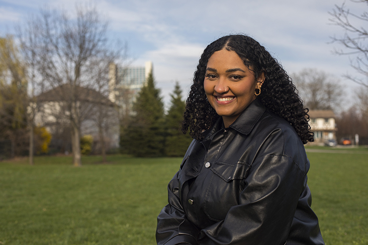 Jalyssa Currie - a smiling young woman standing outside in a community park