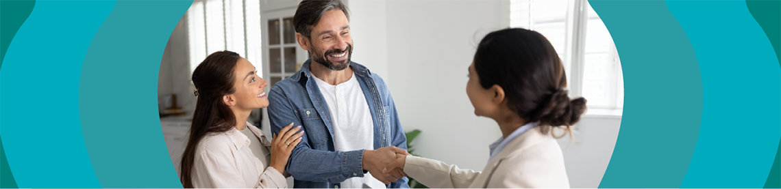 Proud husband and wife shaking hands with a smiling woman