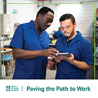 Work mentor and Paving the Path to Work participant in a warehouse looking at a tablet