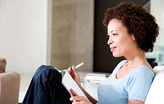Woman relaxing and writing in journal